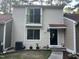 Neutral-toned two-story townhome featuring a small balcony and covered front entryway at 5805 Mapleridge Rd, Raleigh, NC 27609