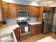 A functional kitchen features wood cabinets, a stainless steel refrigerator, and a range and microwave at 5805 Mapleridge Rd, Raleigh, NC 27609