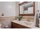 Charming bathroom featuring decorative tiled walls, framed mirror, and granite countertop at 5908 Danville Dr, Raleigh, NC 27612
