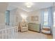 Bright Bedroom features a plush chair, changing table, and window with natural light at 5908 Danville Dr, Raleigh, NC 27612