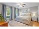 Bright bedroom with large windows, ceiling fan, hardwood floors and neutral paint color at 5908 Danville Dr, Raleigh, NC 27612
