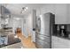 Spacious kitchen with stainless steel refrigerator, granite counters, and easy access to dining area at 5908 Danville Dr, Raleigh, NC 27612