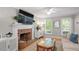 Cozy living room with brick fireplace, stylish cabinet, neutral walls, and ample natural light at 5908 Danville Dr, Raleigh, NC 27612