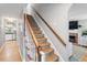 Traditional staircase featuring carpeted steps, a stained wood railing and trim, and neutral paint at 5908 Danville Dr, Raleigh, NC 27612