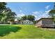 Expansive backyard featuring a large lawn, outbuilding, and mature trees, ideal for outdoor activities and storage at 6005 Lake Wheeler Rd, Raleigh, NC 27603