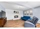 Spacious living room with whitewashed brick fireplace, laminate flooring, and blue furniture at 6005 Lake Wheeler Rd, Raleigh, NC 27603