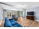 Large basement with laminate flooring, television, and sliding barn door to a separate area at 6005 Lake Wheeler Rd, Raleigh, NC 27603