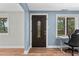 Interior entryway featuring a decorative front door, blue accent walls, and wood-look flooring at 6005 Lake Wheeler Rd, Raleigh, NC 27603