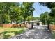 Wide view of the home's exterior, showcasing the fencing, driveway, and landscaping at 6005 Lake Wheeler Rd, Raleigh, NC 27603