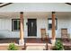 Cozy front porch with rocking chairs, wooden columns, and a decorative front door at 6005 Lake Wheeler Rd, Raleigh, NC 27603