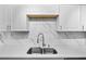 Close up of stainless sink, faucet and quartz countertops with white subway tile backsplash and cabinets at 6005 Lake Wheeler Rd, Raleigh, NC 27603