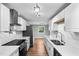 Bright modern kitchen features stainless appliances, white cabinets, quartz counters and wood floors at 6005 Lake Wheeler Rd, Raleigh, NC 27603