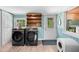 Updated laundry room features new front load washer and dryer, shelves, window, and luxury vinyl flooring at 6005 Lake Wheeler Rd, Raleigh, NC 27603