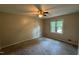 Bright bedroom featuring a ceiling fan, neutral paint and carpet, and a large window for natural light at 609 Sloan Dr, Cary, NC 27511