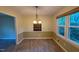 Bright dining room featuring modern light fixture, chair rail, and large window with view of backyard at 609 Sloan Dr, Cary, NC 27511