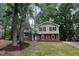 Charming two-story home with brick accents, black shutters and mature trees in a large landscaped front yard at 609 Sloan Dr, Cary, NC 27511