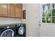 Convenient laundry room includes washer, dryer, cabinets and a door to the exterior at 609 Sloan Dr, Cary, NC 27511