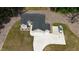 A top-down aerial view of a home with a three-car garage, car in driveway, and a neatly manicured lawn at 620 Rollins Mill Rd, Holly Springs, NC 27540