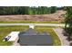 Aerial shot of a house with a three-car garage, manicured lawn, and long driveway to the main road at 620 Rollins Mill Rd, Holly Springs, NC 27540
