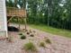 Landscaped backyard featuring a wooden deck, greenery, and wooded backdrop at 620 Rollins Mill Rd, Holly Springs, NC 27540