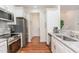 Well-lit kitchen features stainless steel appliances, white cabinets, and granite countertops at 620 Rollins Mill Rd, Holly Springs, NC 27540