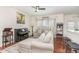 Bright living room with a large sofa, a piano, and natural light from the windows at 620 Rollins Mill Rd, Holly Springs, NC 27540