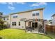 Home's backyard featuring a covered patio with chairs, a fire pit, and lush green grass at 634 Stapleford Ln, Fuquay Varina, NC 27526