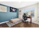Well-lit bedroom featuring a workspace, wood floors, and an accent wall for added visual interest at 634 Stapleford Ln, Fuquay Varina, NC 27526