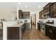Modern kitchen with granite countertops, stainless steel appliances, and dark cabinets; open to the living spaces at 634 Stapleford Ln, Fuquay Varina, NC 27526