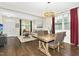 Living room and dining room featuring modern chandelier, rustic wood table, and convenient access to other living areas at 634 Stapleford Ln, Fuquay Varina, NC 27526