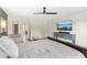 Spacious main bedroom featuring dark wood floors, ceiling fan, TV, and doorway to ensuite bathroom at 634 Stapleford Ln, Fuquay Varina, NC 27526