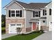 Charming two-story home with a gray exterior, stone accents, and a two-car garage for convenient parking at 6657 Gibraltar Rock Dr, Raleigh, NC 27610