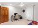Neutral bedroom with a wood door, ceiling fan, desk and computer at 701 Bennington Dr, Raleigh, NC 27615