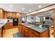 Open kitchen featuring a granite countertop island with a stovetop, custom cabinetry, and connection to living area at 701 Bennington Dr, Raleigh, NC 27615