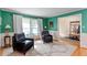 Inviting living room with windows and stylish decor, hardwood flooring, and green walls at 701 Bennington Dr, Raleigh, NC 27615