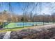 Community tennis courts surrounded by a fence and mature trees in the background at 701 Bennington Dr, Raleigh, NC 27615