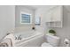 Relaxing bathroom with a jetted tub, tile surround, and decorative glass block window at 745 Oaks Lane Rd, Timberlake, NC 27583