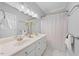 Bright bathroom featuring a double vanity, framed mirror, and ample lighting at 745 Oaks Lane Rd, Timberlake, NC 27583