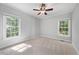 Bright bedroom with neutral carpet, trim detail, and abundant natural light from two windows at 745 Oaks Lane Rd, Timberlake, NC 27583