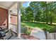 Cozy covered front porch with rocking chair, brick flooring, and a scenic view of the expansive front lawn at 745 Oaks Lane Rd, Timberlake, NC 27583