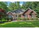 Charming red brick home with a well-manicured lawn, mature trees, and covered porch entrance at 745 Oaks Lane Rd, Timberlake, NC 27583