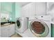 Well-equipped laundry room featuring a sink, modern washer and dryer, and ample storage cabinets at 745 Oaks Lane Rd, Timberlake, NC 27583