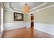 Formal dining room featuring hardwood floors, wainscoting, and stylish light fixture at 7801 Kingsbrook Ct, Wake Forest, NC 27587