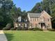 Attractive brick two-story home with a manicured green lawn and mature trees at 7801 Kingsbrook Ct, Wake Forest, NC 27587