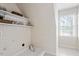 Bright laundry room with white tile, shelving, and ample natural light at 7801 Kingsbrook Ct, Wake Forest, NC 27587