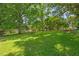 Expansive backyard featuring a lush lawn and mature trees, perfect for outdoor activities at 813 N Main St, Burlington, NC 27217
