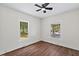 A bright bedroom with hardwood floors and natural light from two large windows at 813 N Main St, Burlington, NC 27217