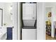 Efficient laundry closet with stacked washer and dryer located near a bathroom with navy vanity at 815 Daniels St # A, Raleigh, NC 27605