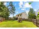 Fenced backyard featuring a lawn, playset, and a covered patio, perfect for outdoor activities and relaxation at 822 Blue Lake Dr, Mebane, NC 27302