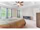 Spacious bedroom with a tray ceiling, ceiling fan, and large windows, offering a comfortable and well-lit environment at 822 Blue Lake Dr, Mebane, NC 27302